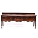 An 18th Century country oak standing dresser, circa 1760, raised back, moulded top, triple frieze
