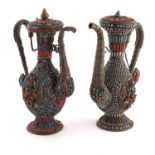 A pair of Persian white metal and jewelled ewers