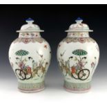 A pair of 18th Century Chinese vases and covers, of bombe form, domed covers with finials, decorated