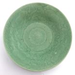 A 18th century or later Chinese celadon glaze charger, underglaze central petal within a scrolling