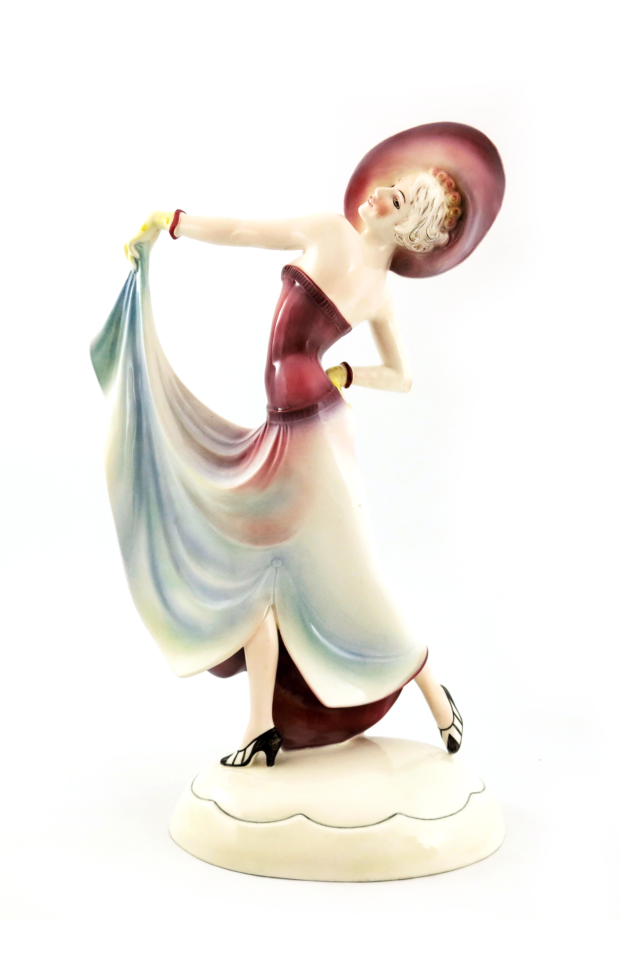 Stephan Dakon for Katzhutte Hertwig, an Art Deco figure of a woman in variegated pink dress and hat