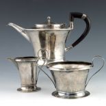 A E Jones, an Arts and Crafts silver three piece tea set, Birmingham 1903