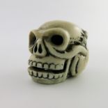 λ A Japanese ivory netsuke, Meiji period, 1868-1912, carved in the form of a human skull with