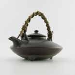 A Japanese ceramic sake kettle, cane handle, marks to base, 14cm high including handle