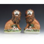 A pair of Staffordshire pottery Lion and Lamb figures, circa 1860, modelled seated with a lamb, on p