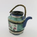 A Japanese Banko ware teapot, cane loop handle, enamelled panels with an exotic bird and floral