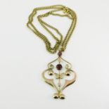 A 9ct yellow gold garnet set pendant, double ogee scroll form