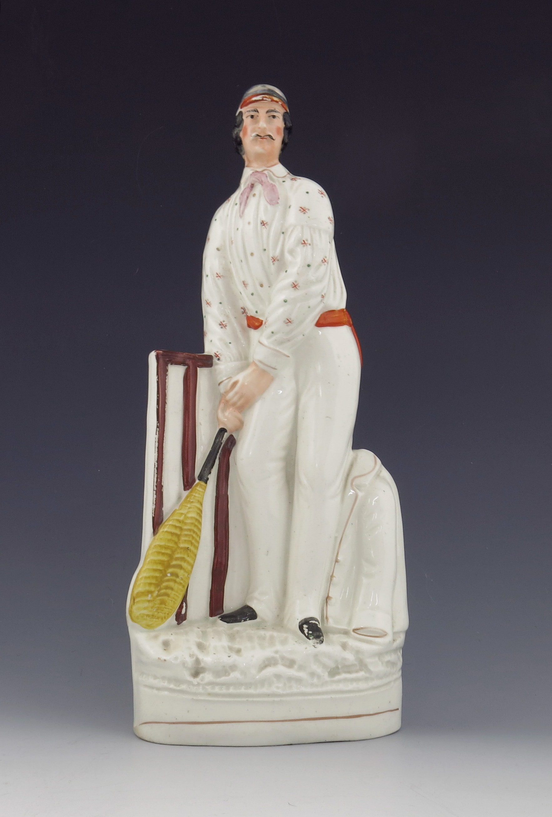 A Staffordshire figure of a cricketer, circa 1860, modelled as a batsmen at the wicket, standing bes