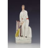 A Staffordshire figure of a cricketer, circa 1860, modelled as a batsmen at the wicket, standing bes