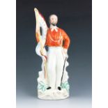 A Staffordshire figure of Garibaldi, circa 1865, modelled standing, holding a flag titled 'Liberté',