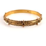 An Edwardian 9ct yellow gold hinged bangle