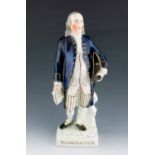 A Staffordshire figure of George Washington, circa 1855, modelled standing, holding a hat and a scro