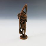 A treen netsuke, carved as a standing bearded elder with another elder upon his shoulder clutching a