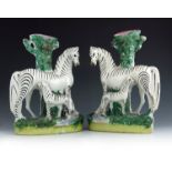 A pair of Staffordshire flat back zebra and foal spill vases, circa 1860, modelled as a zebra standi