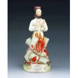 A Staffordshire figure of 'Archbishop Cranmer' burning at the stake, circa 1860, modelled standing s