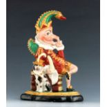 A Staffordshire doorstop figure of Mr. Punch, circa 1860, modelled reclining beside his dog against