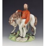 A Staffordshire figure of Garibaldi, circa 1865, modelled standing beside his horse, on a naturalist