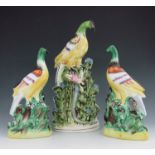 A pair of Staffordshire pottery exotic birds, circa 1850, modelled perched on a green and brown moun