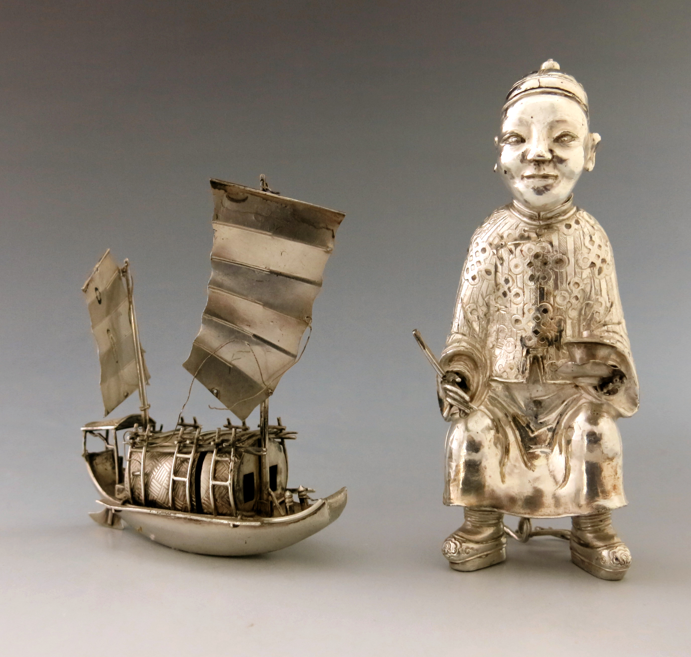 A novelty Chinese white metal condiment, early 20th Century, in the form of a seated Mandarin,