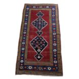 An antique Caucasian Kazak rug, of linked medallion design, 260 by 135cm