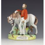 A Staffordshire figure of Garibaldi, circa 1865, modelled standing beside his horse, on a naturalist