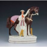 A Staffordshire figure of Solomon Rarey, circa 1860, modelled standing next to his horse Cruiser, po