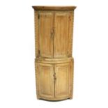 A George III country pine demi-lune floor standing corner cupboard, circa 1800, plain moulded