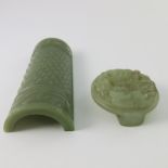 A Chinese green jade armrest, stud and beast carved, width 12.5cm, together with a circular jade