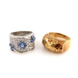 A silver pave gem set floral band, together with a yellow metal planished ring (2)