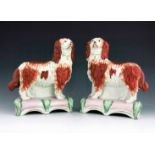 A pair of Staffordshire pottery spaniels, Grace and Majesty, circa 1850, modelled standing on pink a