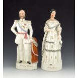 A pair of Staffordshire figures of the King and Queen of Prussia, circa 1870, modelled standing on p