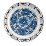 An 18th Century Dutch Delft blue and white circular plate, painted with chrysanthemum within a