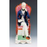 A Staffordshire figure of the Duke of Wellington, circa 1850, modelled seated in a spoon back armcha