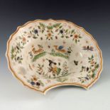 A 19th Century French faience barber's bowl, decorated in polychrome with a central figure of a