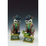 A pair of Chinese ornamental models of shi shi beasts, each in coloured enamels, one with a ball,