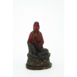 A Chinese moulded red translucent figure of a seated female deity, raised on a lotus leaf, gilt