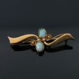 An 18 carat gold and opal brooch, two opposing open coiled tendril wings with two oval cabochon