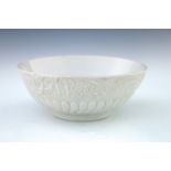 A Chinese blanc de chine footed bowl, the frieze with moulded design of exotic birds in flight,