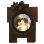 A late 19th Century circular porcelain plaque, painted with a pair of cherubs in an embrace, 14cm