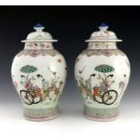 A pair of 18th/19th century Chinese vases and covers, of bombe form, domed covers with finials,