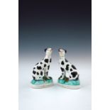 A pair of mid 19th Century Staffordshire chimney dogs, circa 1860, seated with blackberry spots,