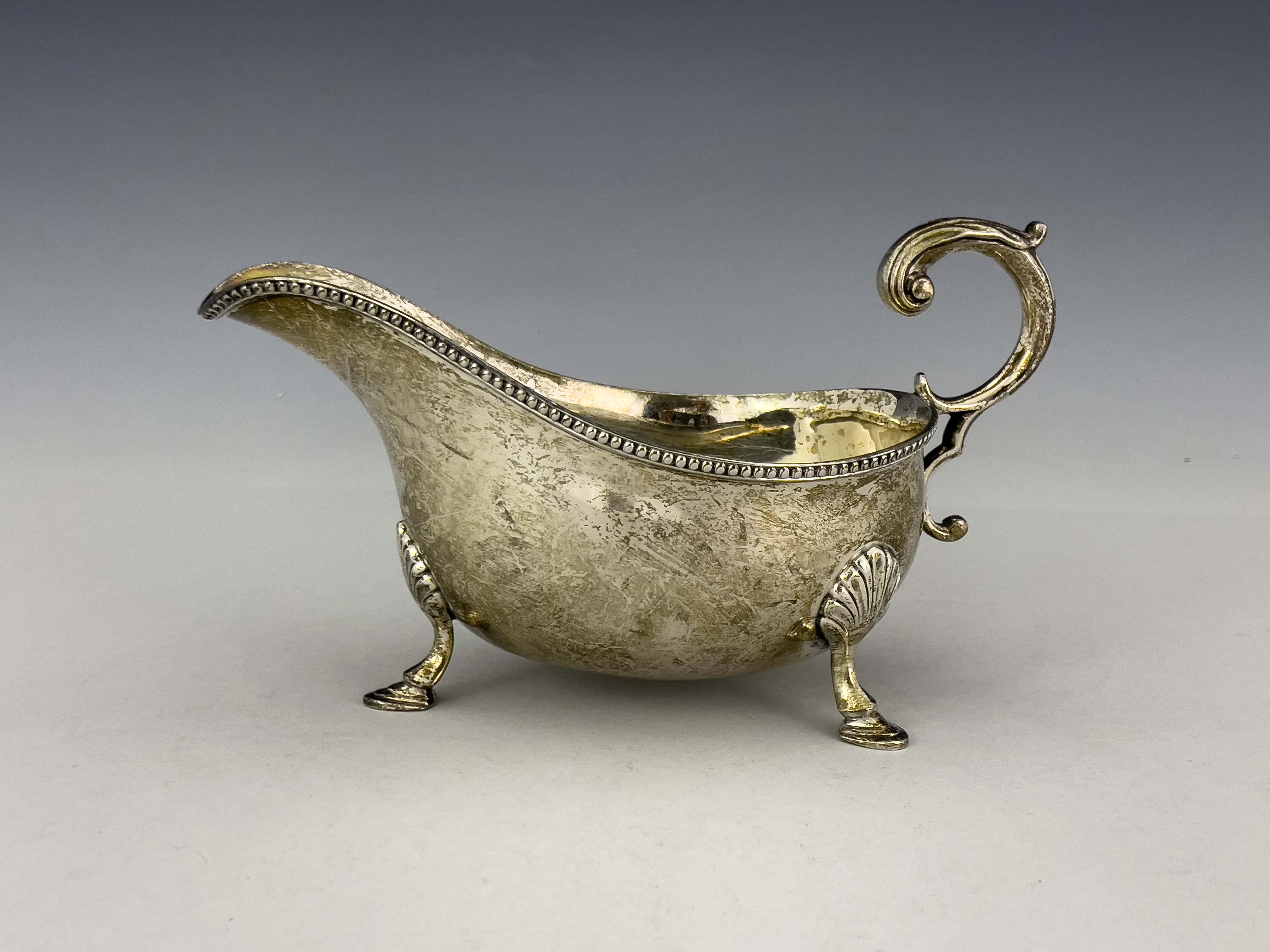 A large George V silver sauce boat, William Hutton, Sheffield 1926, helmet form with beaded rim,