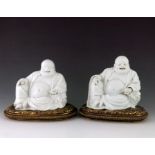 A pair of Chinese blanc de chine Buddhas, 19th Century, the smiling figures seated in repose with