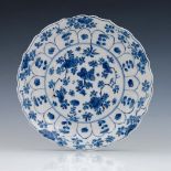 A Chinese blue and white plate, Kangxi mark and probably of the period, ogee rim, painted with