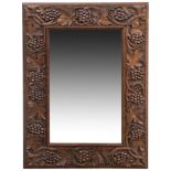 Arthur Simpson (attributed), an Arts & Crafts wall mirror, the oak frame carved in relief with