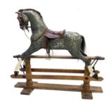 A rocking horse, early 20th Century, dappled grey with tan leather saddle and tack, stained pine