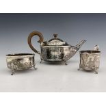 A E Jones, an Arts & Crafts silver three piece tea set