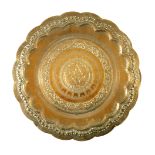 A large brass charger, embossed with central entwined geese within foliate borders and ogee rim,