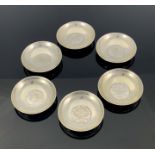 A set of six white metal coin dishes