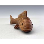 An oriental carved treen model of a fish, realistic fins and gills, glass bead eyes, signed, 16.